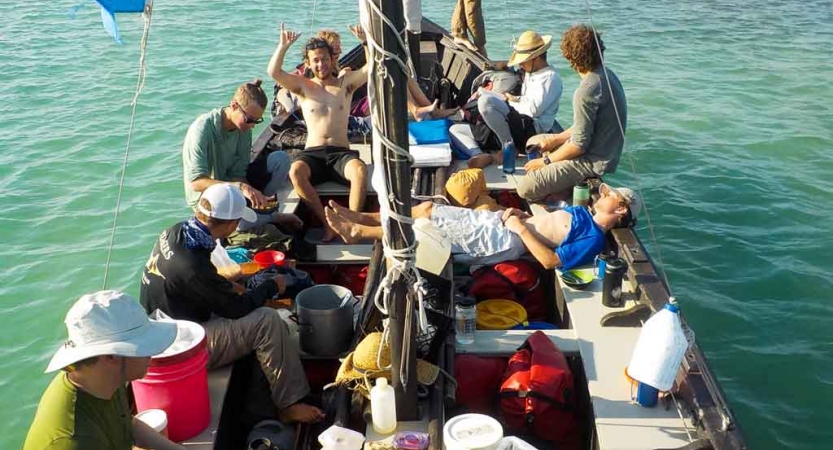 a group of students sit in a sailboat on an outward bound course in florida